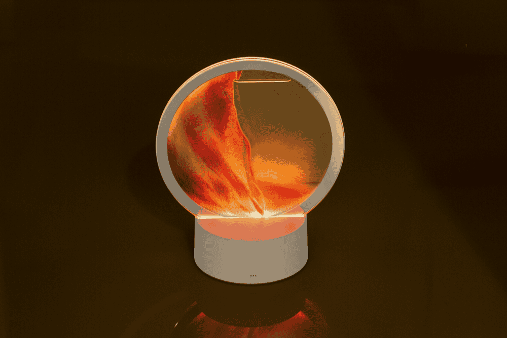 Rotating sand picture, with colour-changing LED