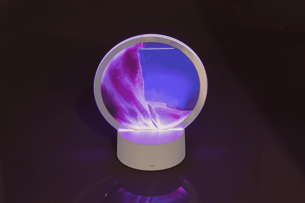 Rotating sand picture, with colour-changing LED